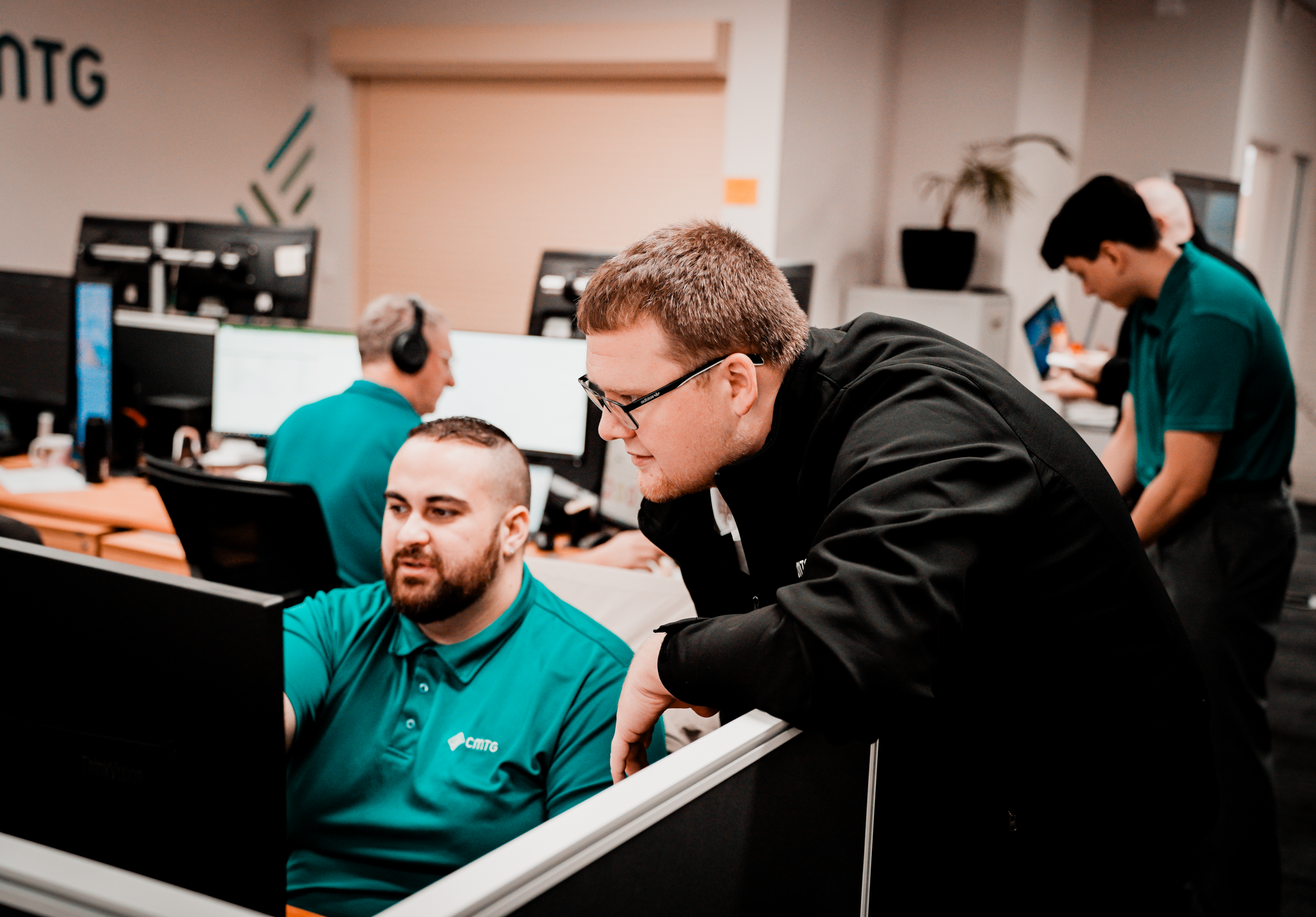 Two CMTG employees working on computers to support reliable business internet Perth solutions for local businesses.