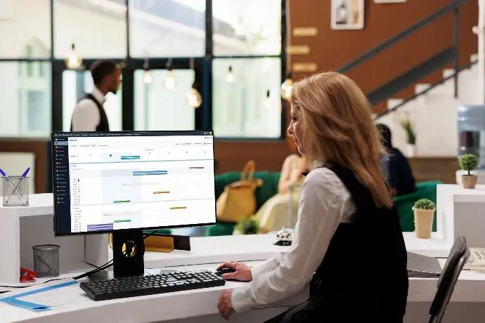 Woman working at a computer in a modern office providing managed IT services Perth for the accommodation and hospitality industry.