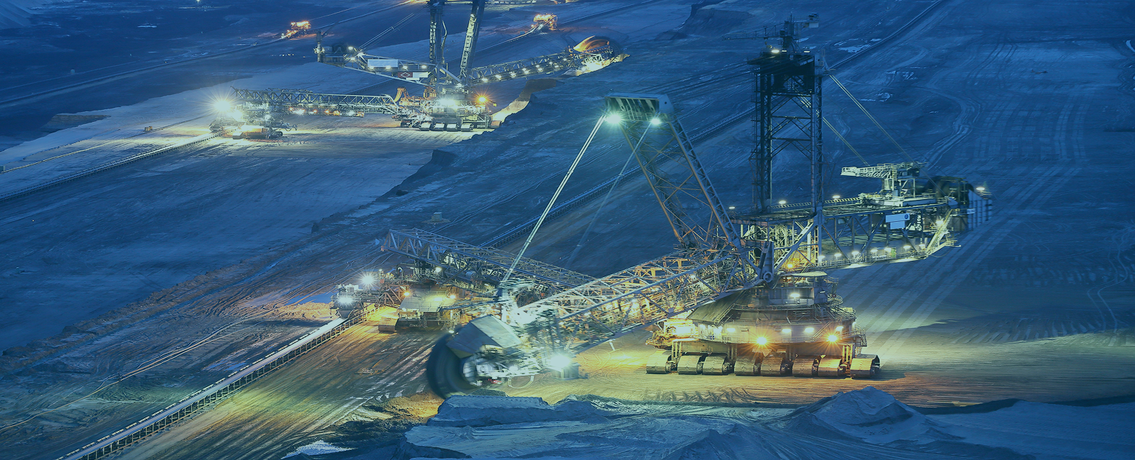 Mining operation at night with illuminated trucks and heavy equipment powered by reliable business internet Perth solutions.