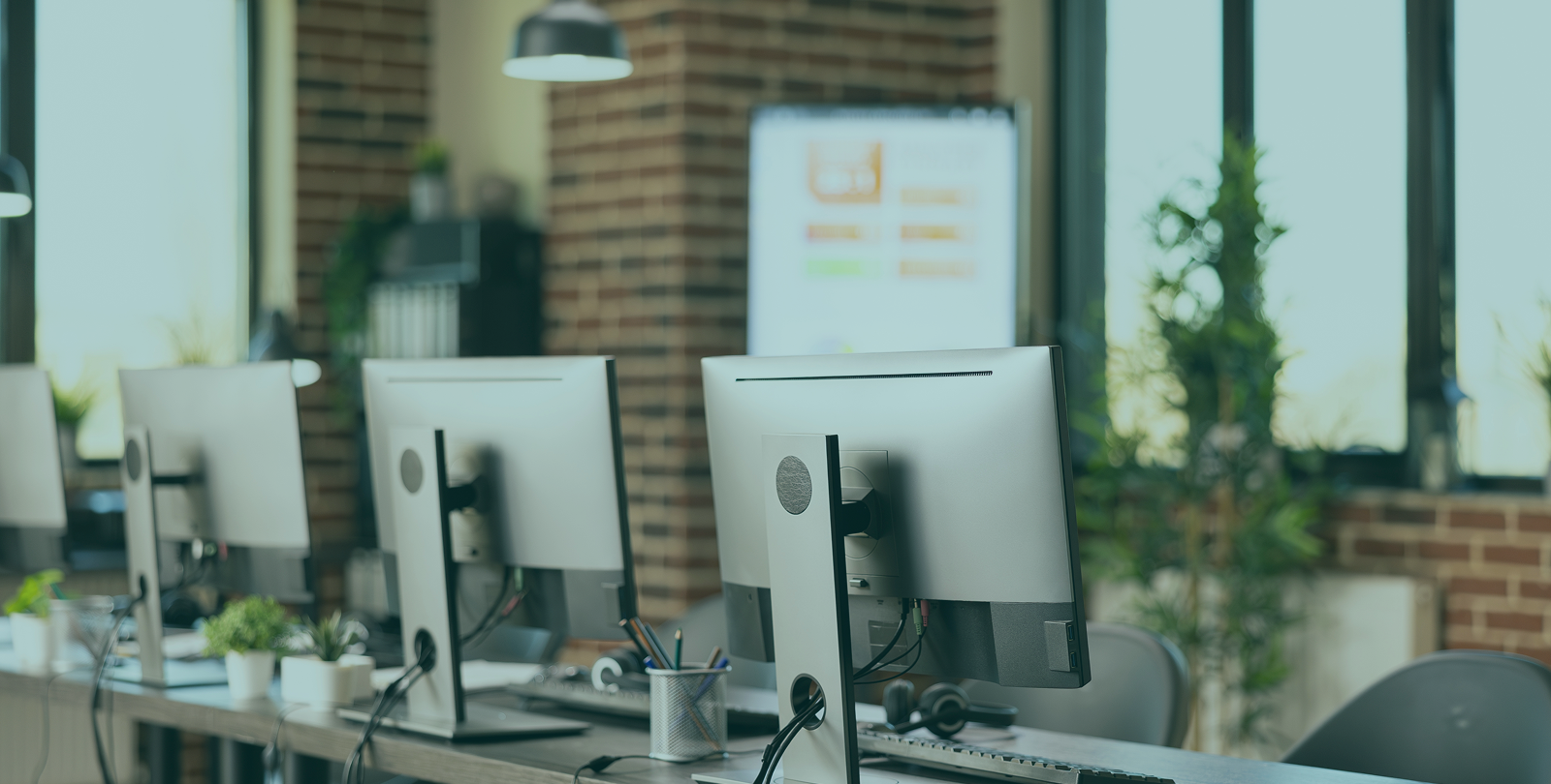 Multiple computer monitors arranged in an office, showcasing cyber security services in Perth
