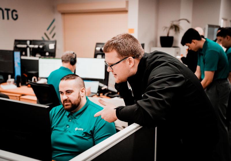 Two CMTG employees working on computers to support reliable business internet Perth solutions for local businesses.